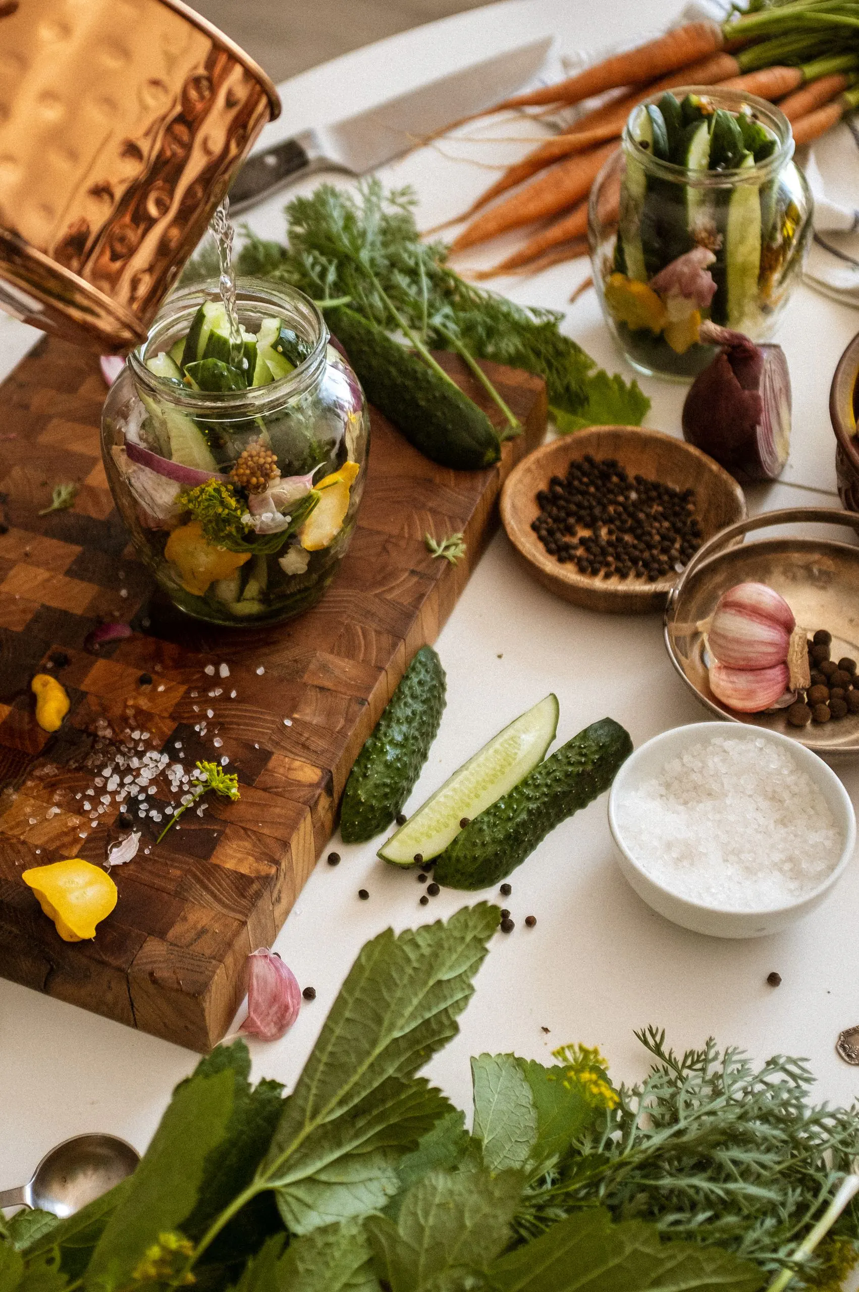 view of fresh ingredients for pickling cucumbers with herbs and spices on a wooden cutting board.